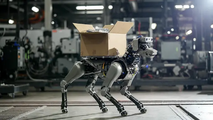 : Quadruped robot with tactile feet carrying an unsecured box across a warehouse floor, featured in this Weekly Robotics News update.