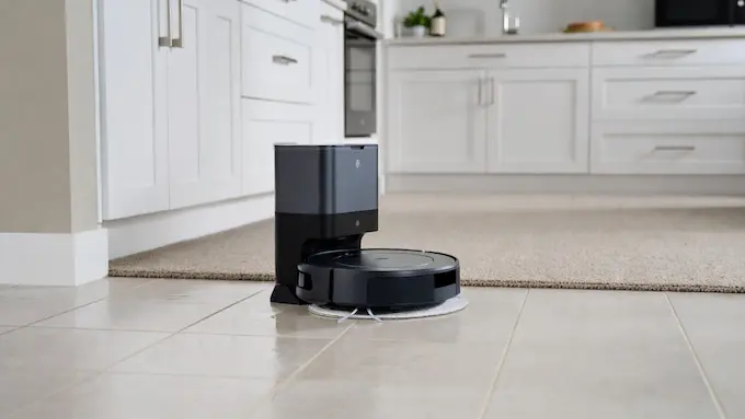 “Roomba Combo robot vacuum and mop cleaning a tile floor near a carpet”